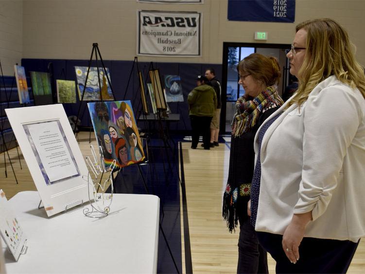 Attendees view some of the artwork submitted at the annual campus and community art show, hosted by the IDREAM Team at Penn State DuBois.